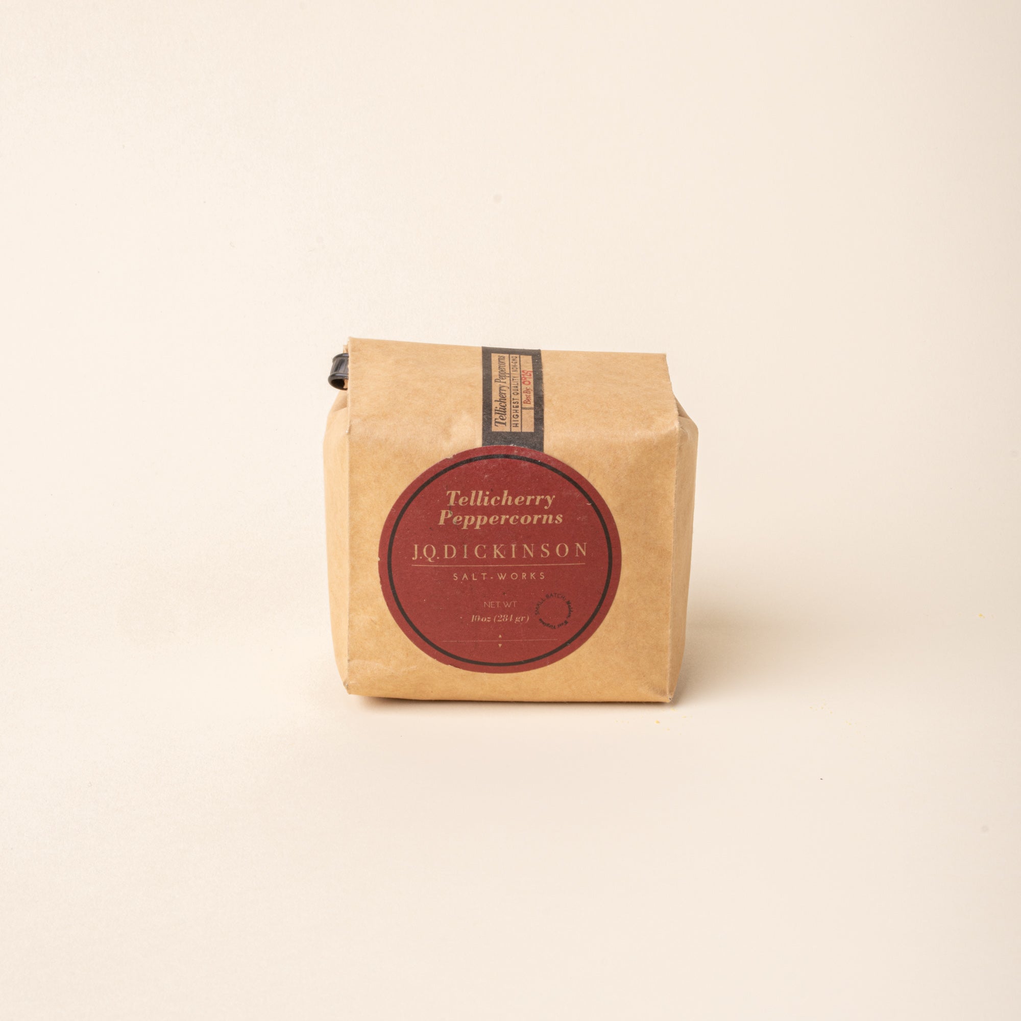 Bag of J.Q. Dickinson Tellicherry Peppercorns on a plain white background.