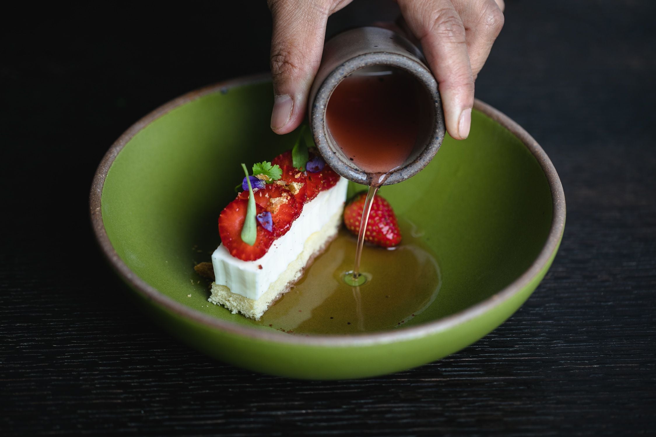 Pouring syrup from a toddler cup into a dessert in an East Fork everyday bowl.